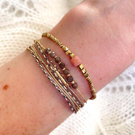 Bracelet cordons doré et taupe et chaîne dorée. Sur l'un d'eux sont montées 7 perles rondes de pierre naturelles de Quartz Fumé brun taupe. Bracelet Solitaire Jaspe Rose, en perle cubique facettée.