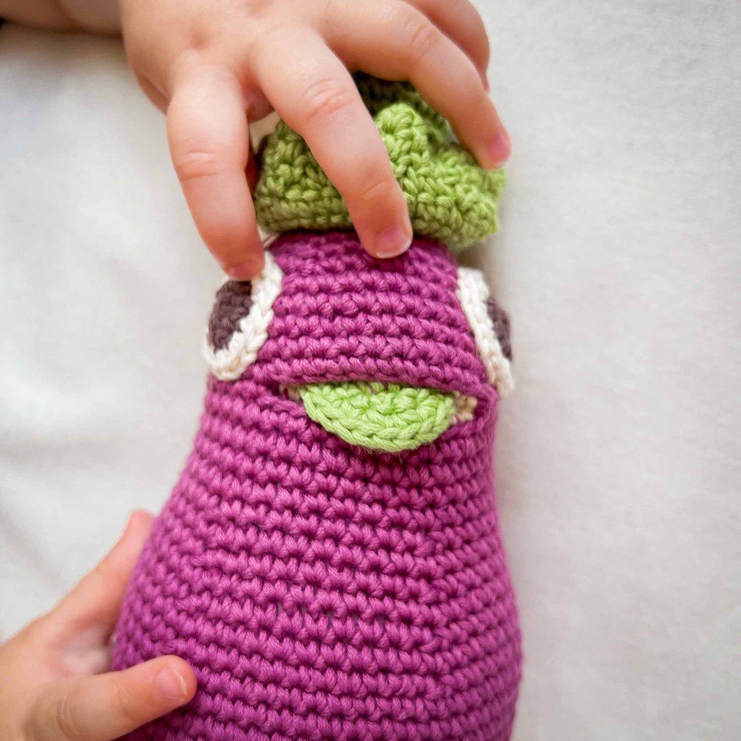 Hochet Aubergine pour bébé en crochet coton bio fait main avec petit grelot. Hauteur 18 cm, couleur aubergine.