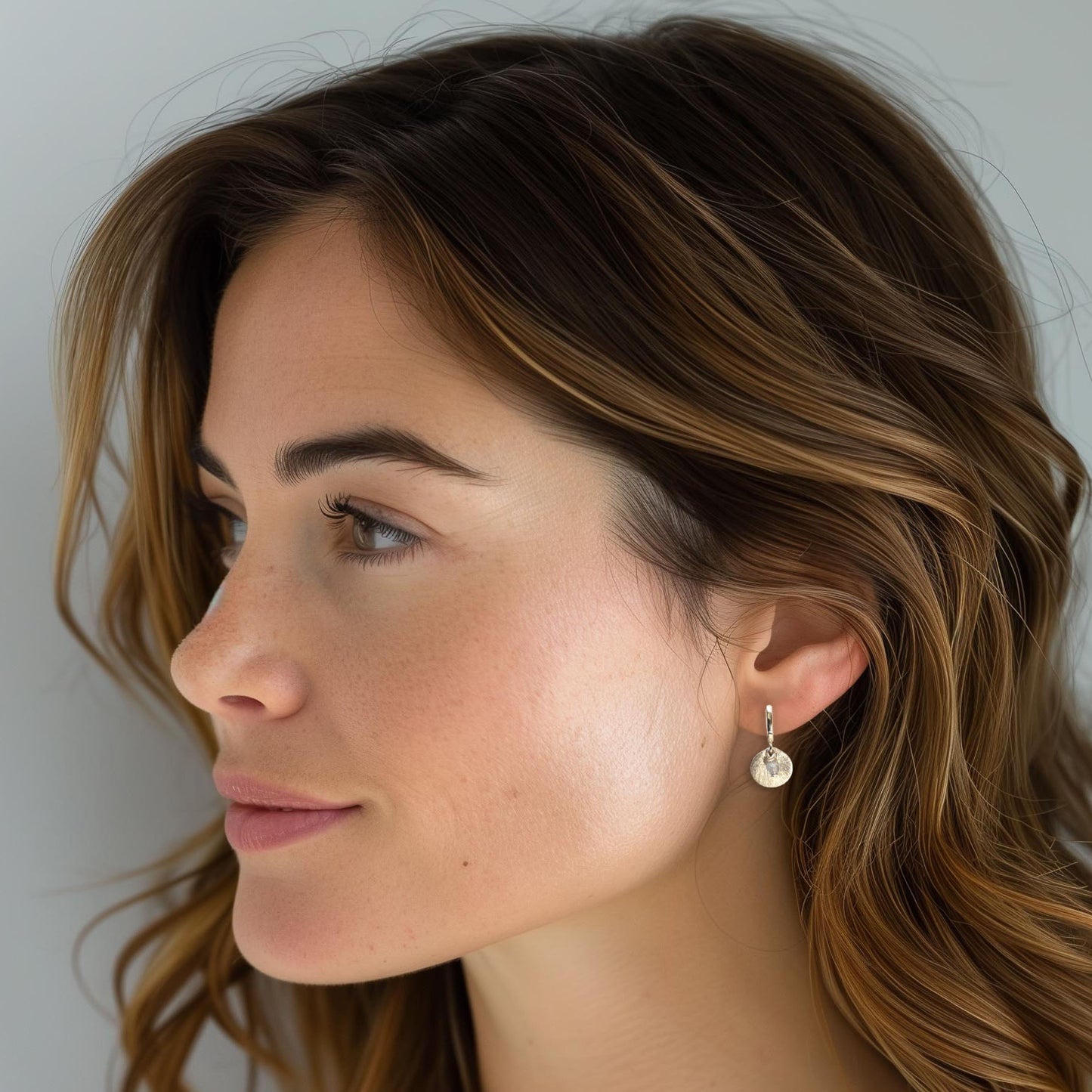 Boucles d'oreilles mini créoles avec pierres fines naturelles de Labradorite grise positionnées sur de petites médailles en plaqué or. Anneaux 1.2 cm de diamètre