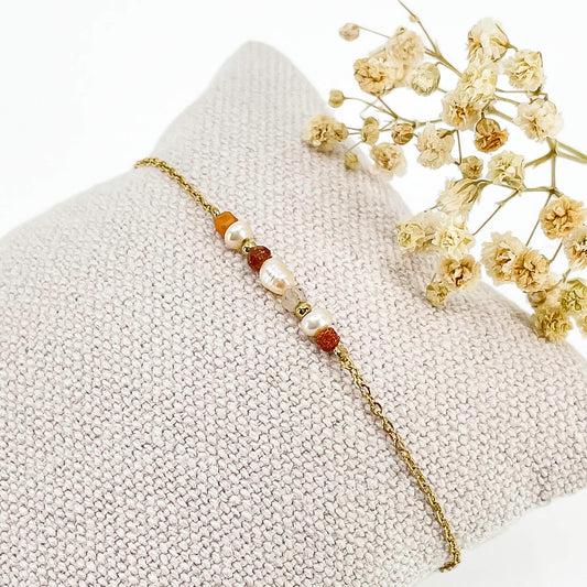 Bracelet monté avec une alternance de perles de culture et de pierres de lune naturelles et perle de verre pailletée de teinte terracotta sur une chaîne dorée.