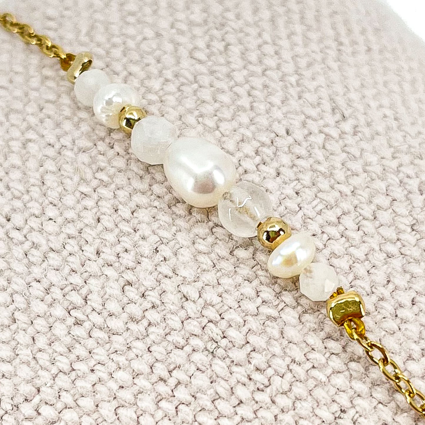 Bracelet monté avec une alternance de perles de culture et de pierres de lune naturelles blanche sur une chaîne dorée.