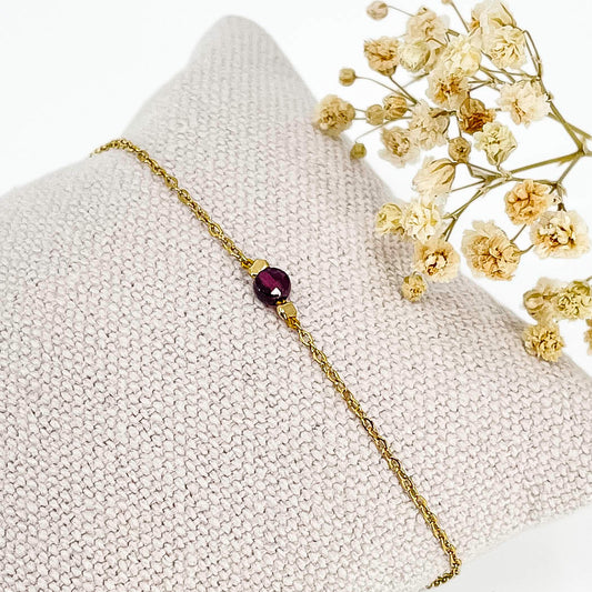 Bracelet perle de pierre naturelle de grenat rouge bordeaux montée sur une chaîne dorée.
