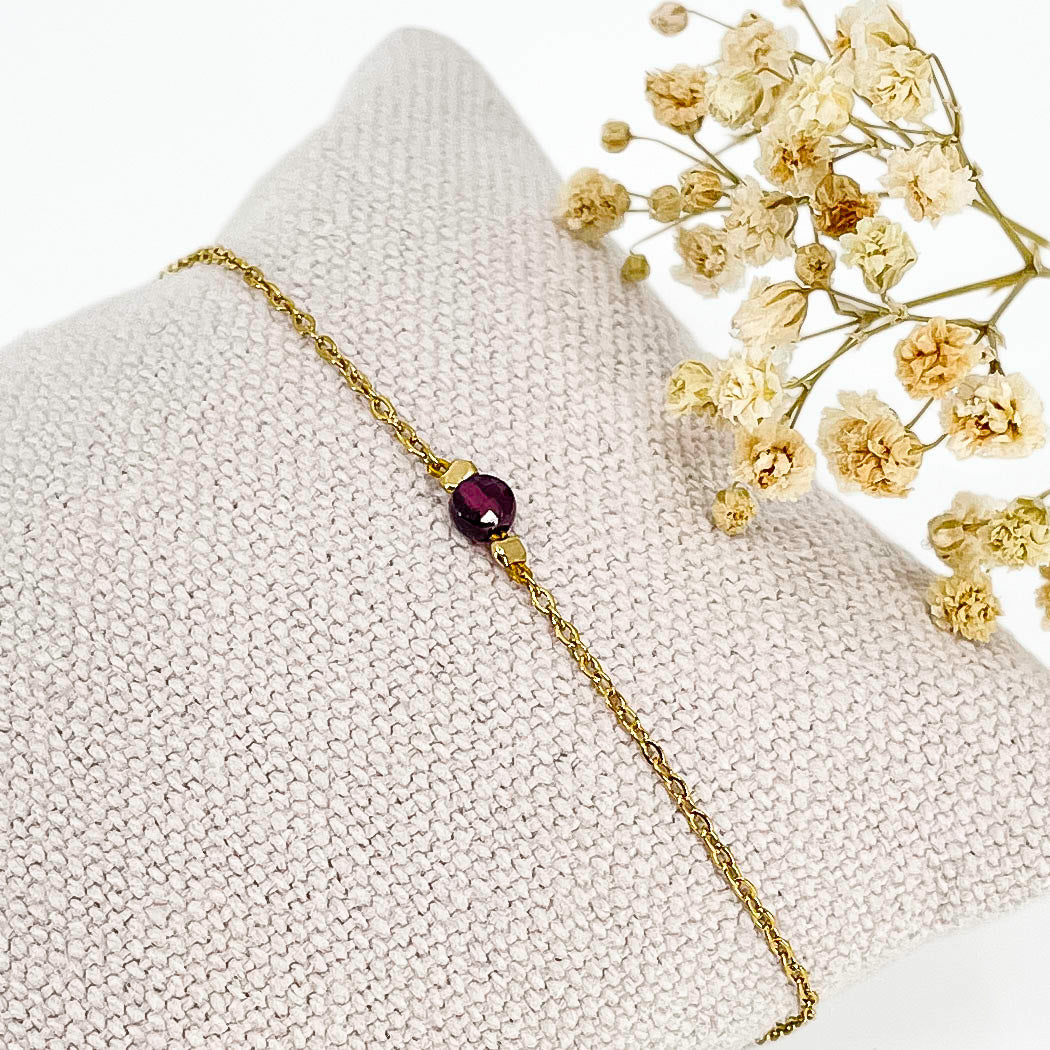 Bracelet perle de pierre naturelle de grenat rouge bordeaux montée sur une chaîne dorée.