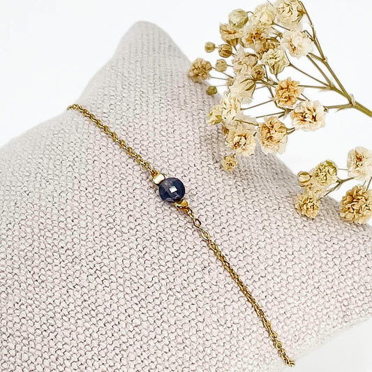 Bracelet perle de iolite bleu comme un solitaire monté sur une chaîne en acier inoxydable doré.