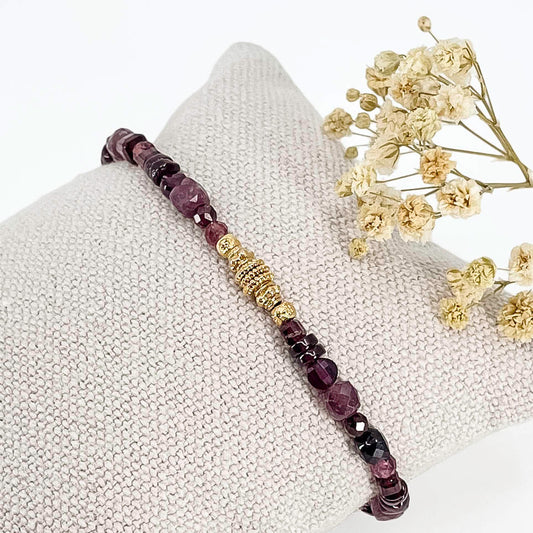 Bracelet pierres naturelles Tourmaline et Grenat dans une déclinaison de teintes bordeaux-rose profond. Perles dorées multiformes au centre du bracelet.