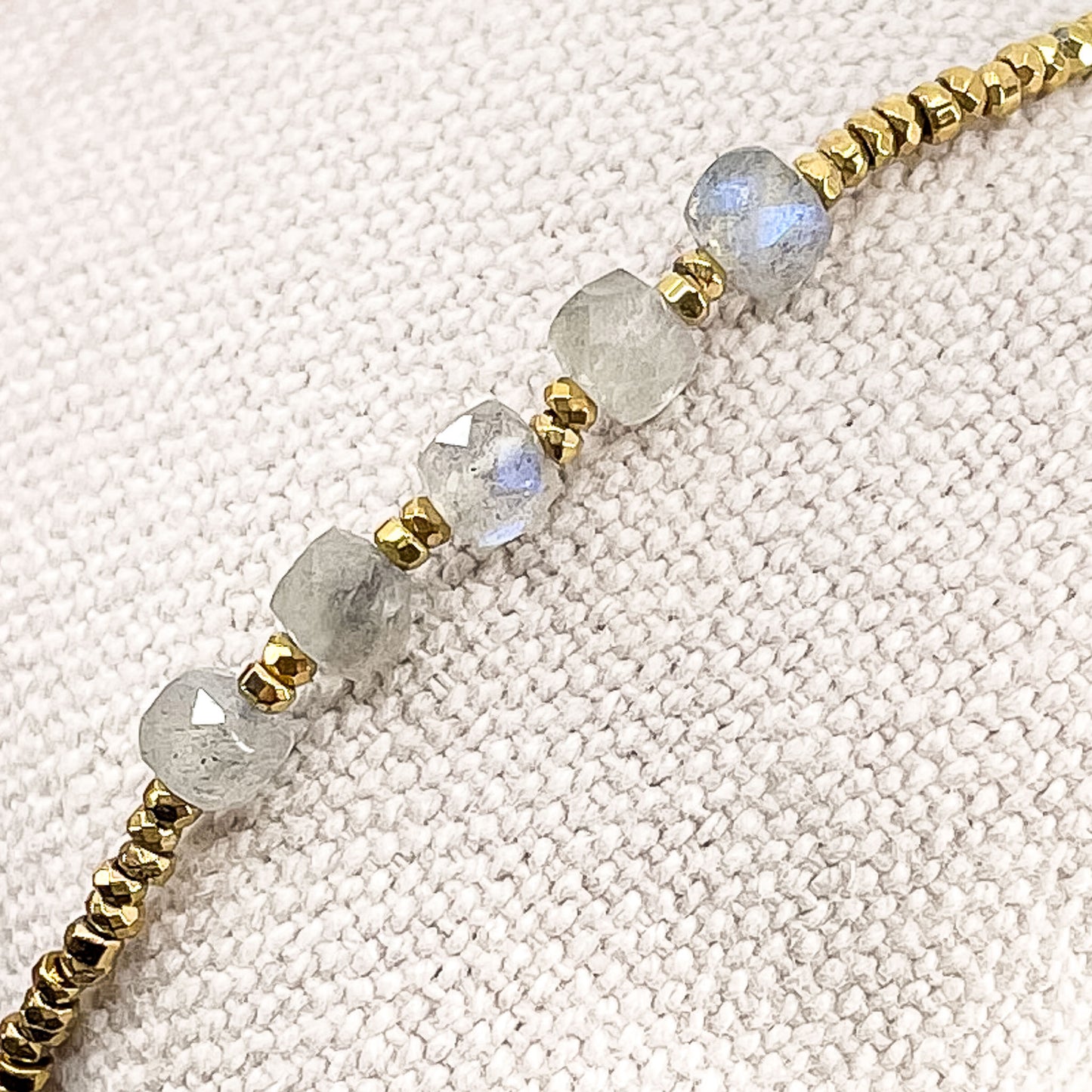 Bracelet en pierres fines naturelles de Labradorite. Cinq belles pierres cubiques facettées de labradorite montées en alternance avec des perles dorées.