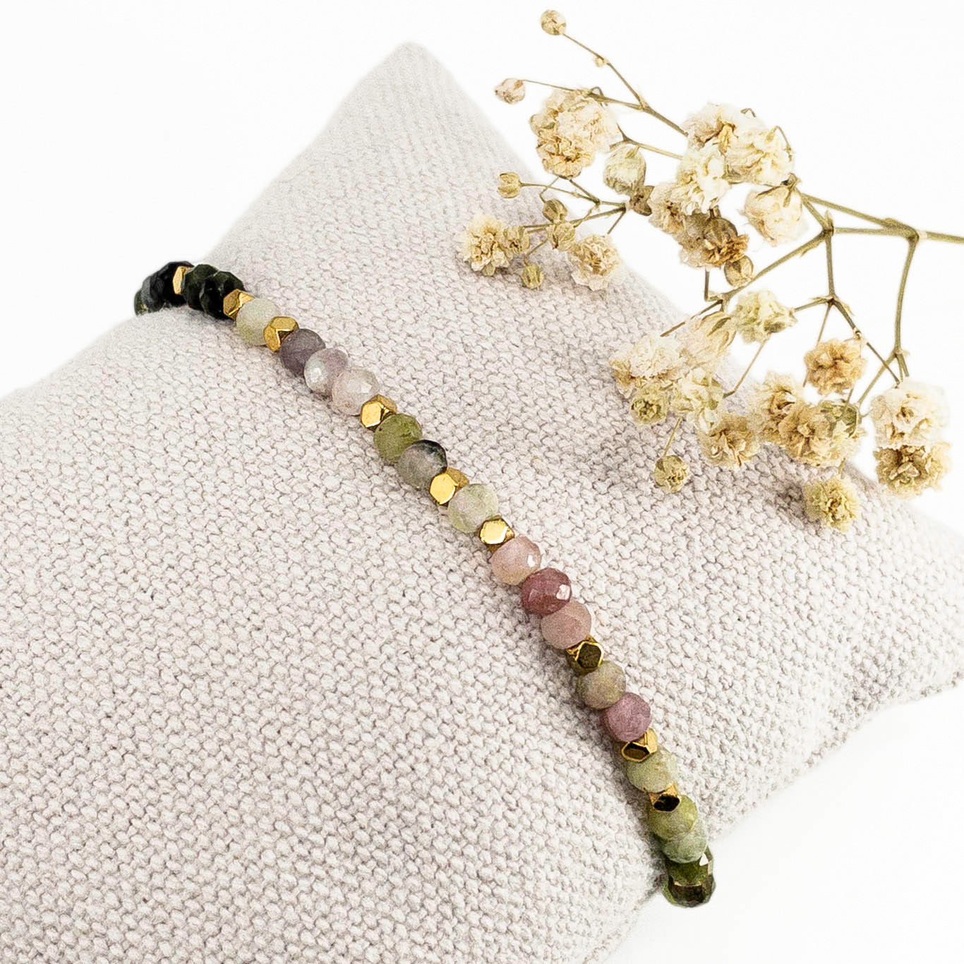 Bracelet ajustable composé de pierres fines naturelles de différentes teintes de Tourmaline ponctuées de perles d'hématites dorées.