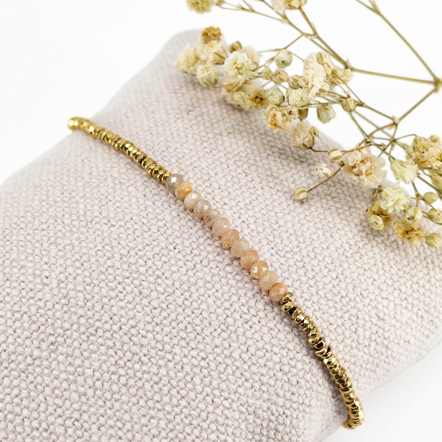 Bracelet ajustable en pierres fines naturelles Pierre de Soleil aux nuances rosées et perles d'hématites dorées.