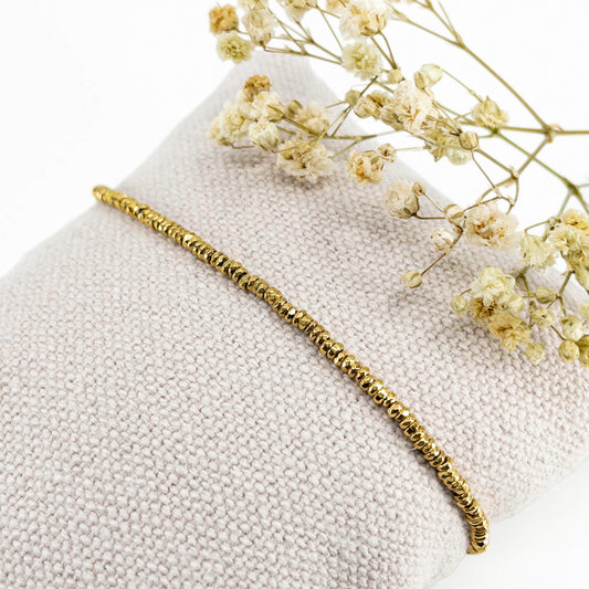 Bracelet en perles de pierre naturelle d'hématite dorée montées sur un cordon ajustable à la taille de votre poignet.
