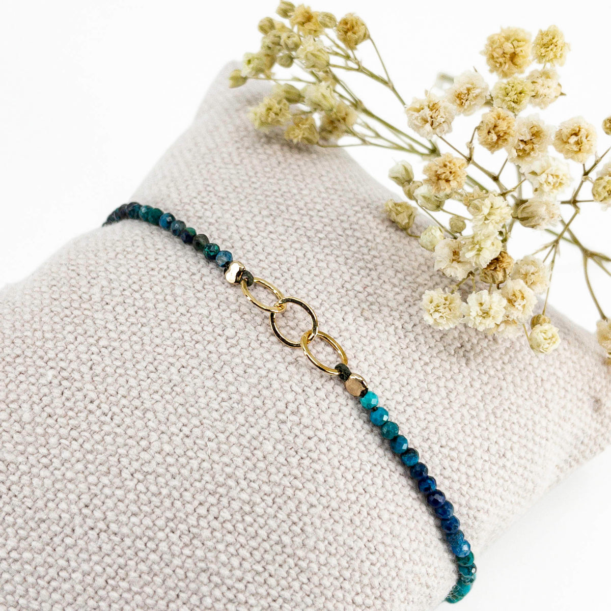 Bracelet réglable en pierres fines naturelles spinelle déclinaison de bleus. Trois anneaux en plaqué or entremêlés