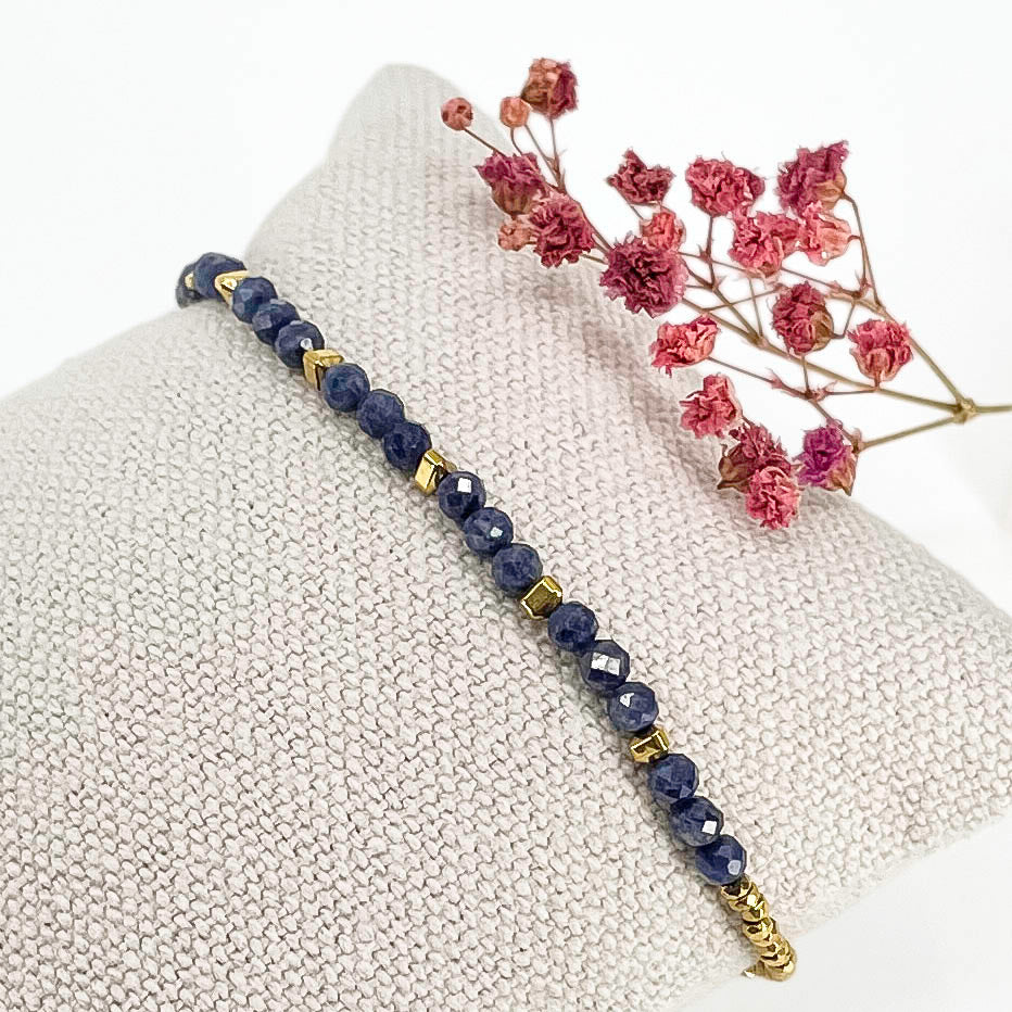 Bracelet en perles rondes de pierre naturelle Oeil du Tigre bleu, alternant avec quelques perles d'hématites dorées.