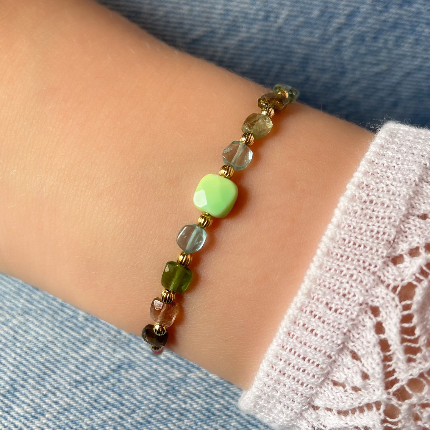 Bracelet ajustable en pierres fines naturelles. Au centre une Agathe d'Herbe carrée verte. Encadrée de six Tourmalines multicolores et deux Aigue-marine.
