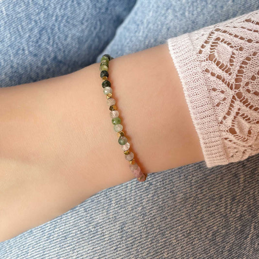 Bracelet ajustable composé de pierres fines naturelles de différentes teintes de Tourmaline ponctuées de perles d'hématites dorées.
