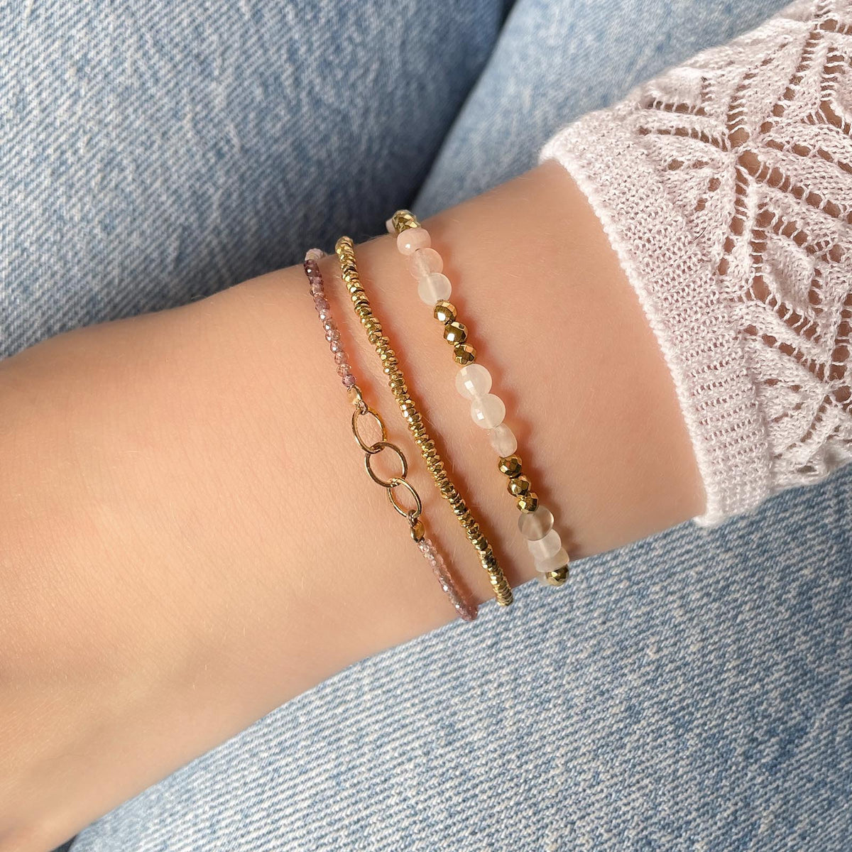 Bracelet réglable en pierres fines naturelles spinelle déclinaison de teinte rose et brune. Trois anneaux en plaqué or entremêlés