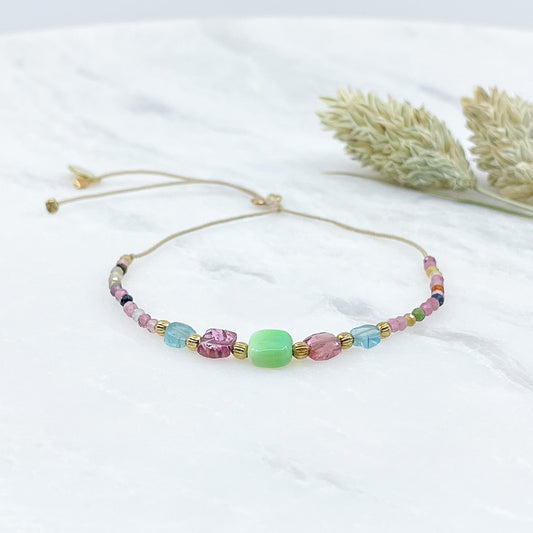 Bracelet ajustable en pierres fines naturelles. Au centre une Agathe d'Herbe carrée verte. Encadrée de deux Tourmalines et deux Aigue-marine.