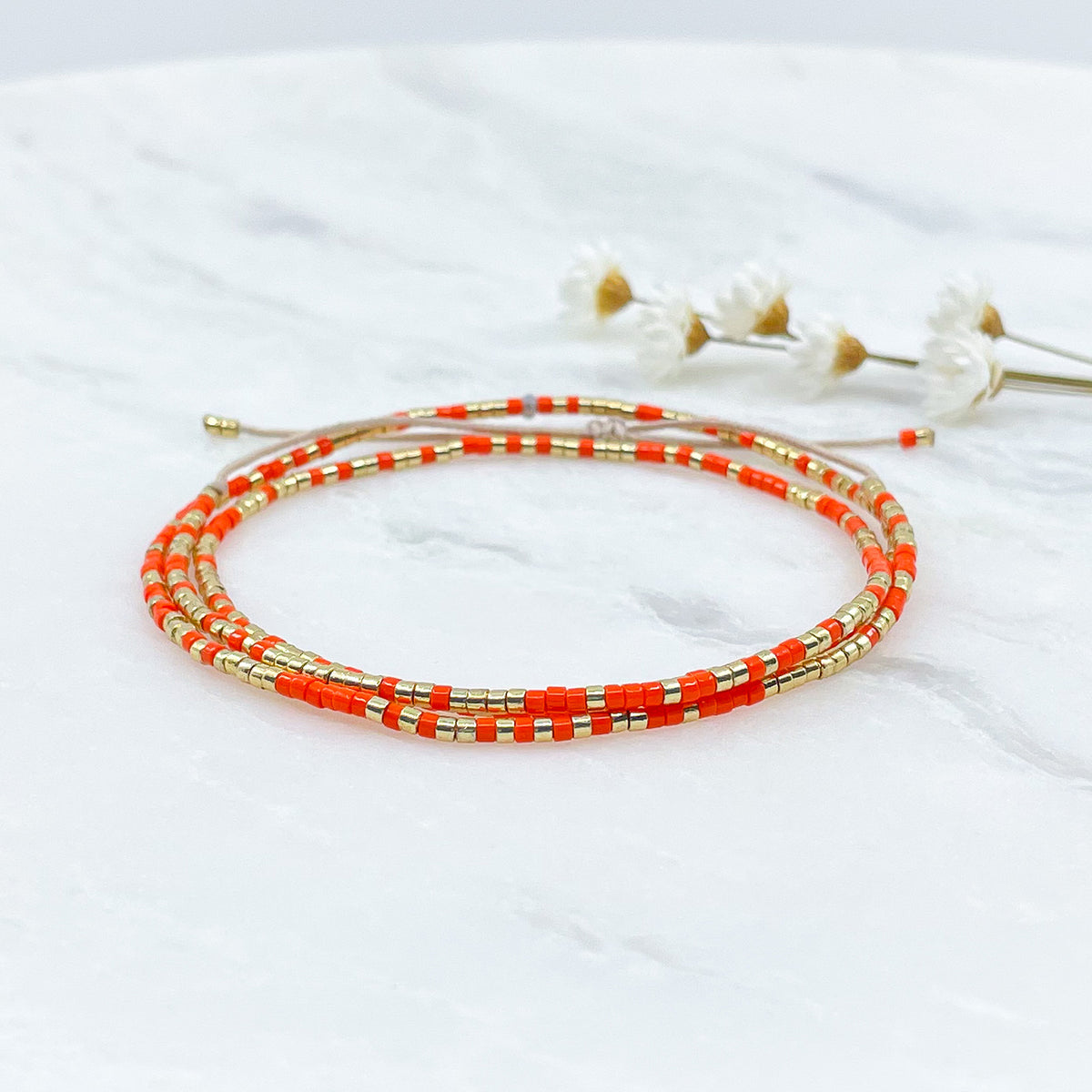Bracelet ajustable en pierre de rocaille orange pétillant et or. Trois tours de poignet