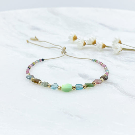 Bracelet ajustable en pierres fines naturelles. Au centre une Agathe d'Herbe carrée verte. Encadrée de six Tourmalines multicolores et deux Aigue-marine.