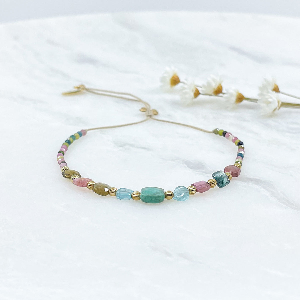 Bracelet ajustable en pierres fines naturelles. Au centre une Agathe d'Herbe carrée verte. Encadrée de six Tourmalines multicolores et deux Aigue-marine.