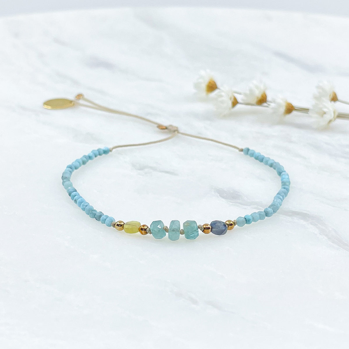 Bracelet ajustable composé de pierres fines naturelles offrant une déclinaison de bleu : perles de pierres de Larimar, de Grandidierite et de Tourmaline