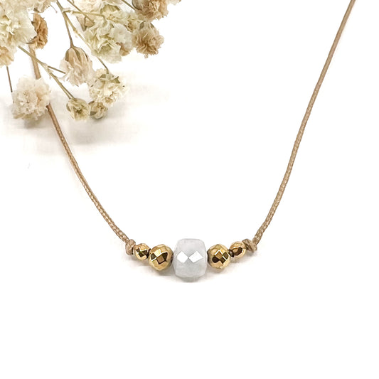 Collier cordon taille ajustable mettant en valeur une perle carrée facettée de pierre fine naturelle de Quartz Blanc entourée d'Hématite dorée.