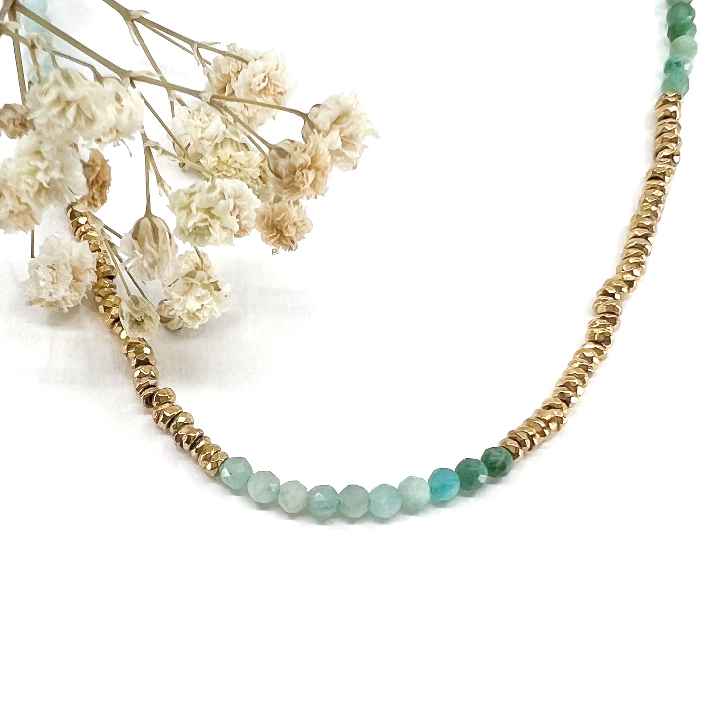 Collier en pierres fines naturelles d'amazonite aux différentes teintes de vert et hématite dorée. Longueur ajustable de 38-43 cm. Fermoir et chaîne d'extension en plaqué or.