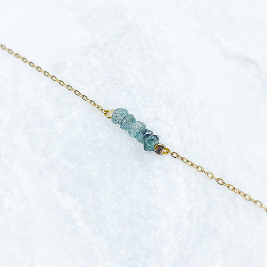 Collier en pierres fines naturelles de Tourmaline aux déclinaison bleu-vert. 5 pierres montées sur une chaîne en acier inoxydable doré.