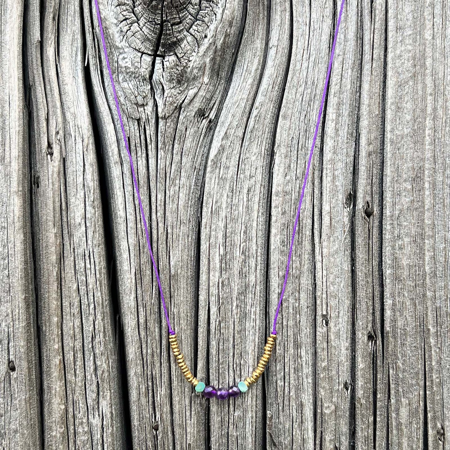 Collier sur cordon ajustable. Pierres fines naturelles : 3 perles d'améthyste encradrées par deux perles de Turquoise et des hématites dorées.