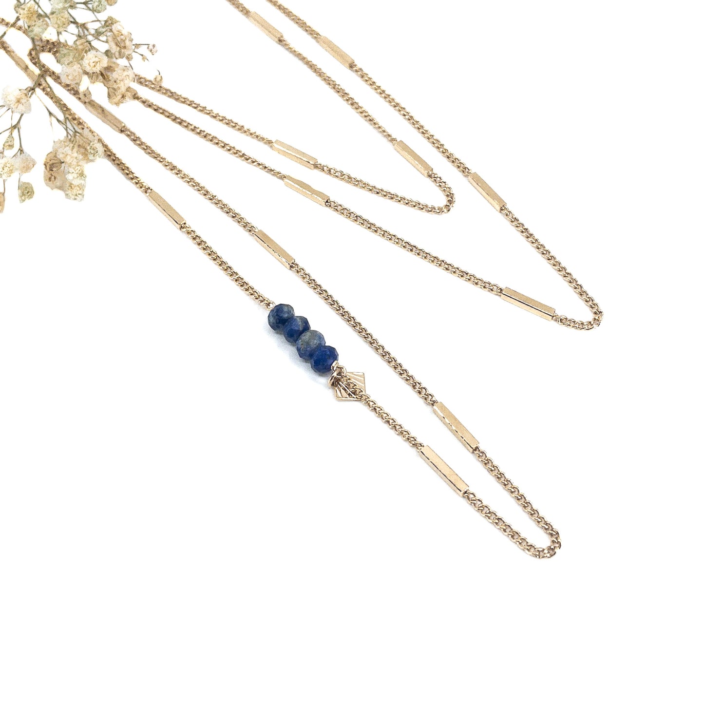 Collier sautoir long 85cm chaîne plaqué or recyclé. 4 pierres fines naturelles de sodalite d'un bleu profond ponctuent le côté du sautoir. Alternance de mailles longues rectangulaires sur une chaîne classique
