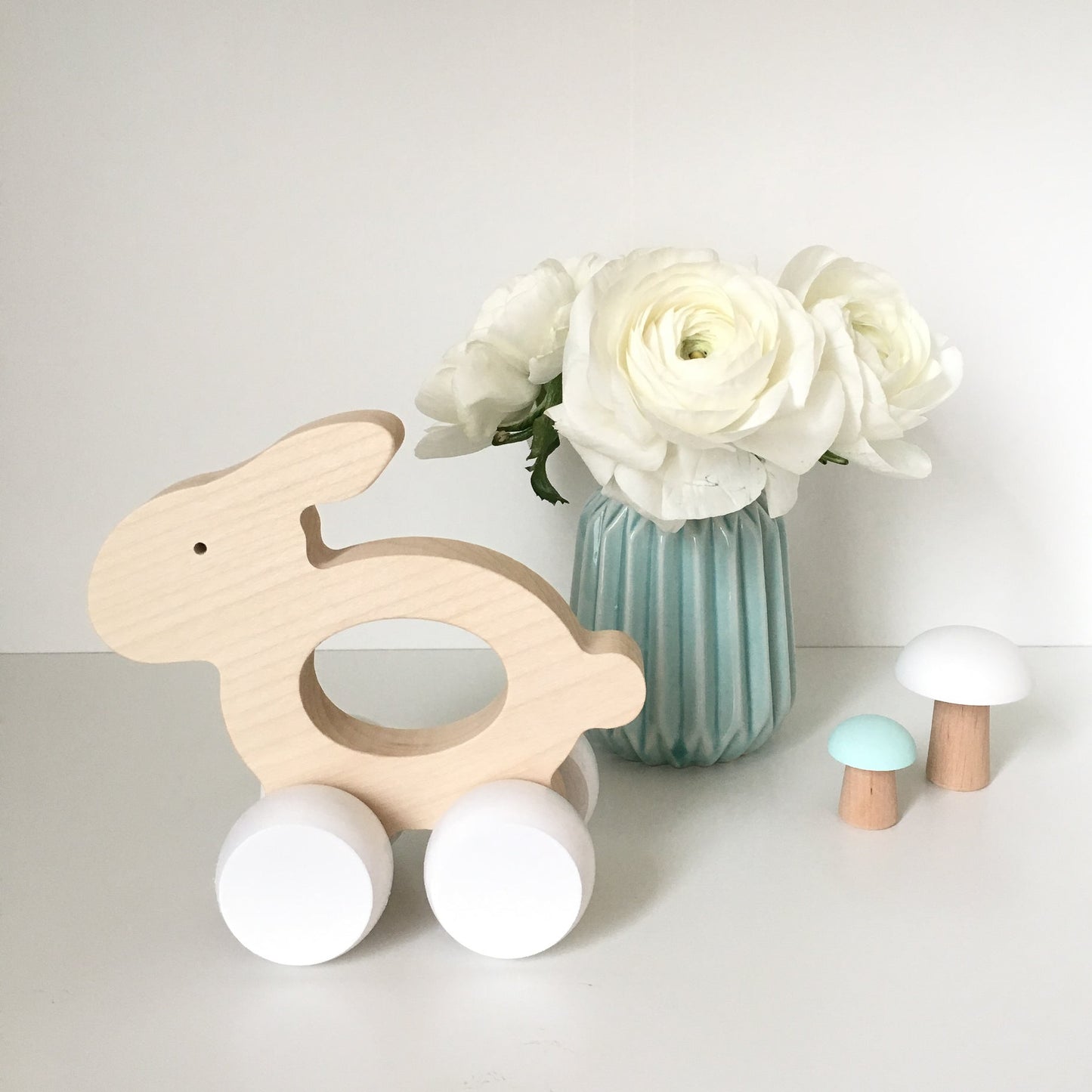 Jouet en bois fait main. Lapin en bois naturel, roues blanches. Jouet à pousser