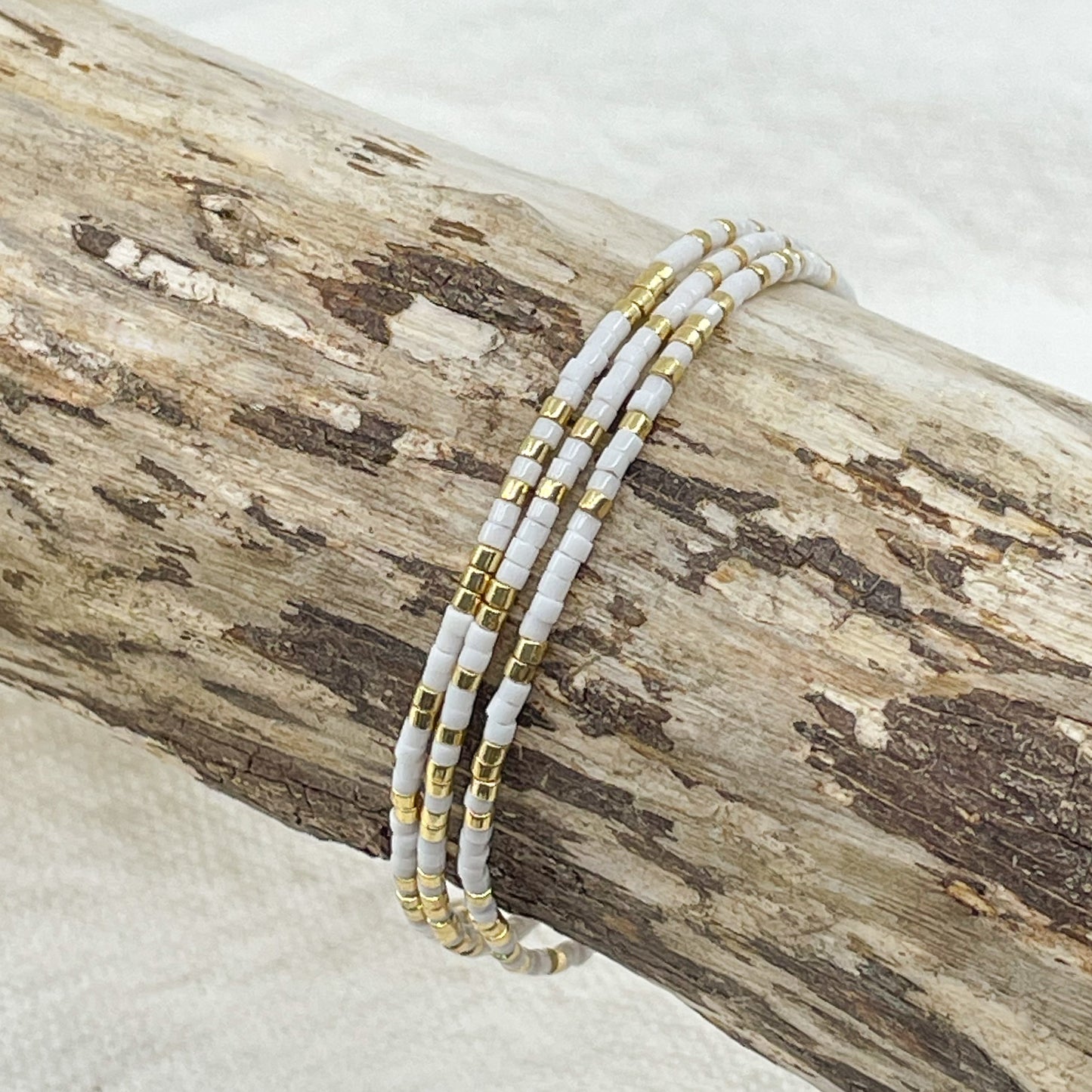 Bracelet ajustable en pierre de rocaille blanc et or. Trois tours de poignet