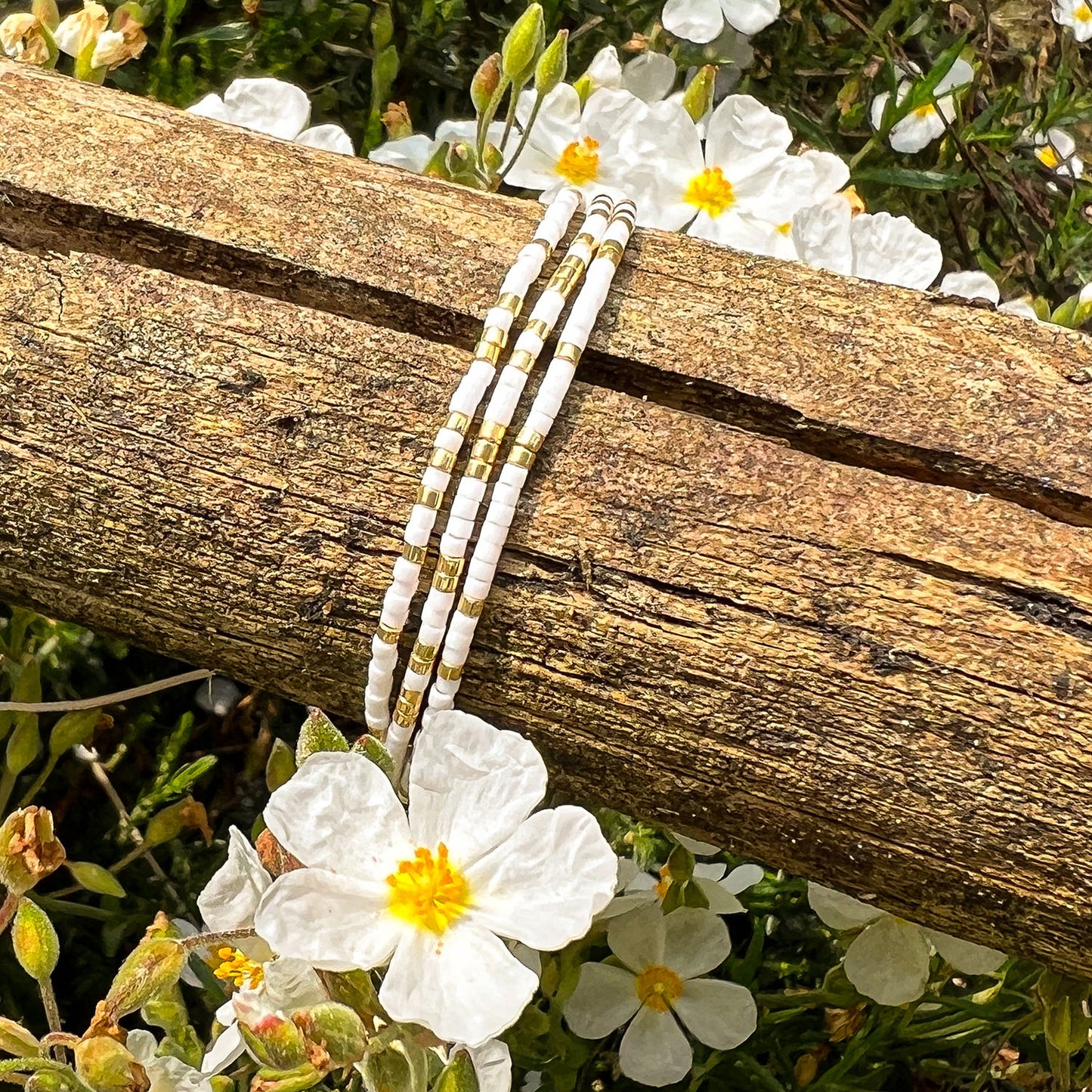 Bracelet ajustable en pierre de rocaille blanc et or. Trois tours de poignet