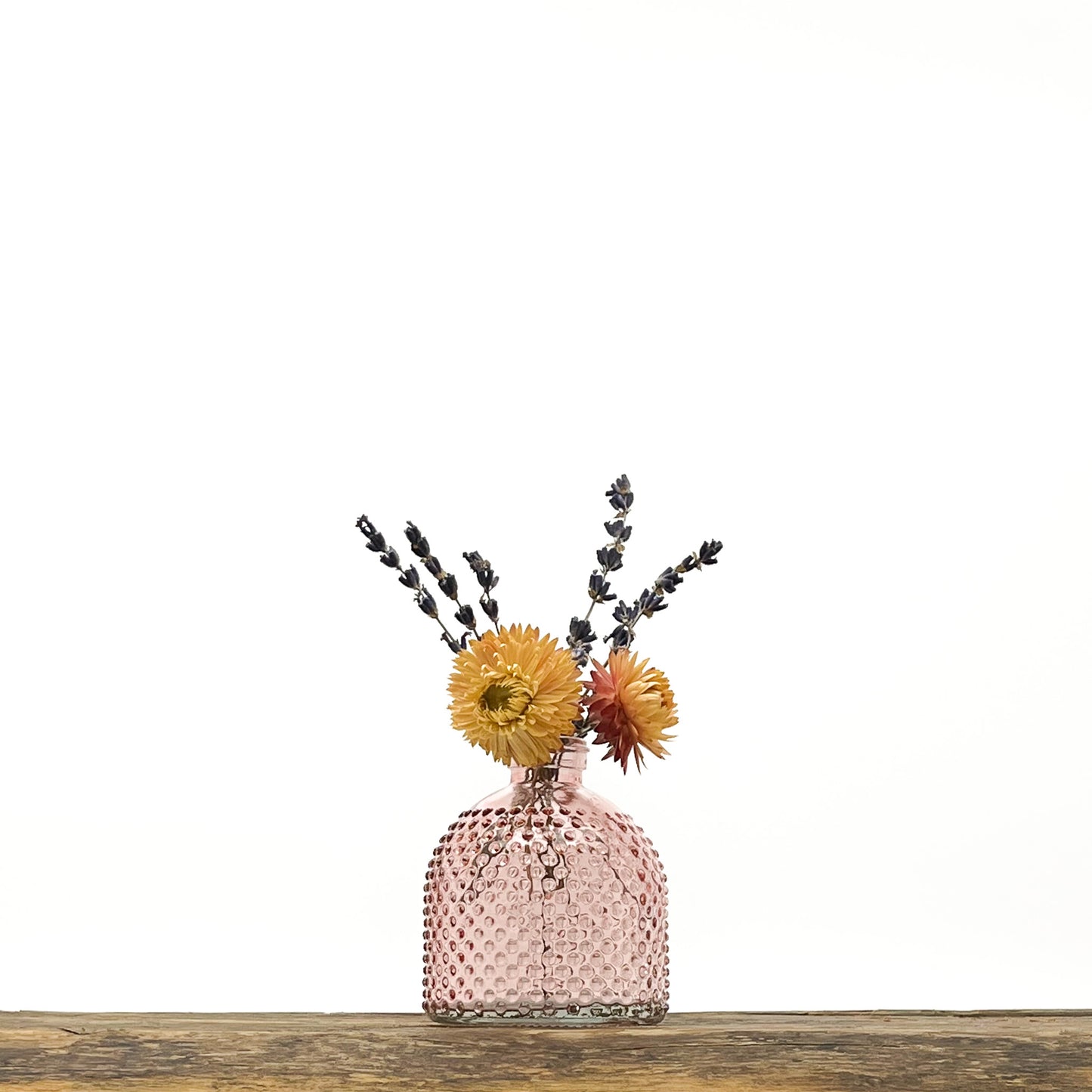 Ensemble de 3 vases en verre, deux dans les tons rosé, le troisième translucide. Design différencié et harmonieux. Livrés avec fleurs séchées offertes.