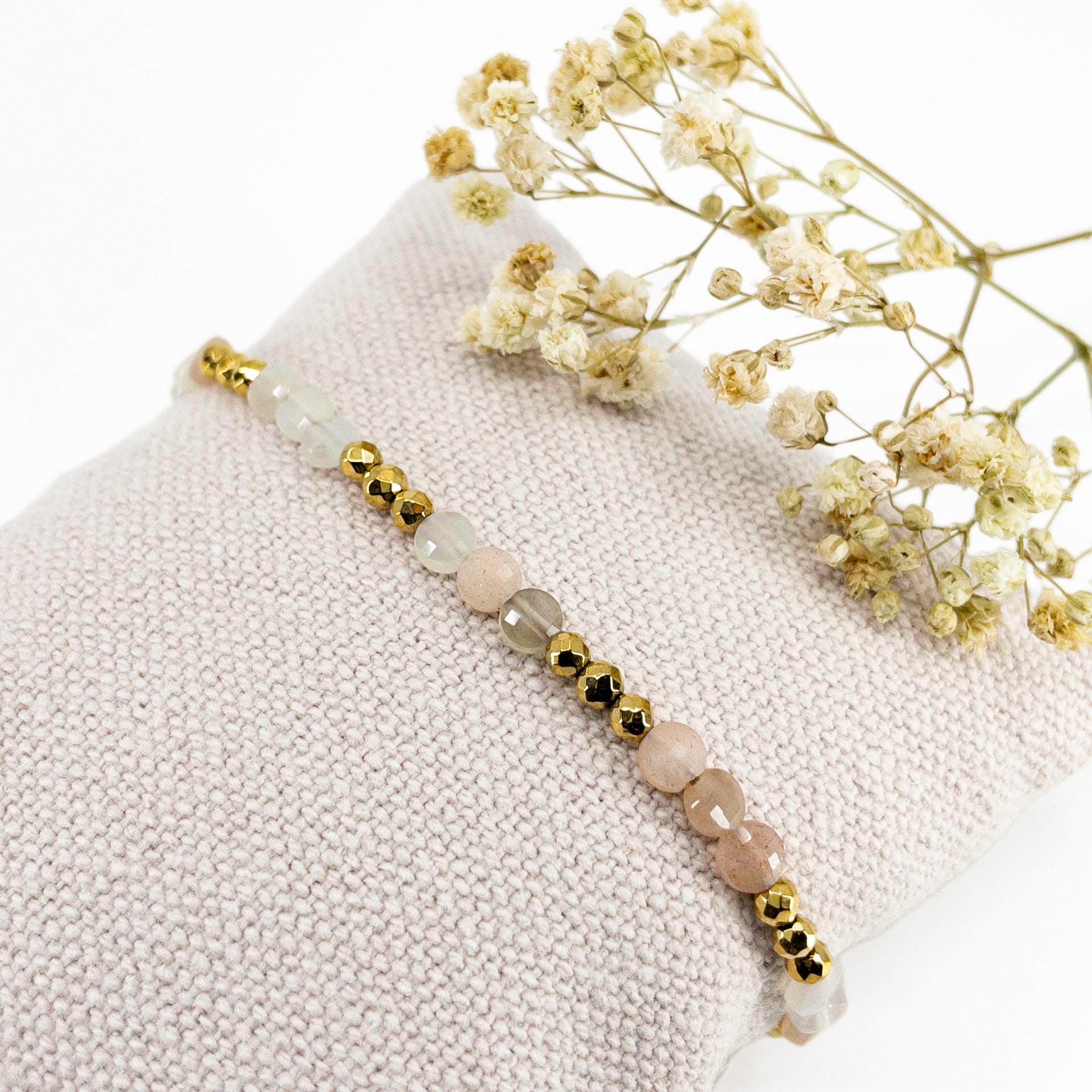Bracelet ajustable en pierres fines naturelles Pierre de Soleil aux nuances blanches et rosées et perles d'hématites dorées.