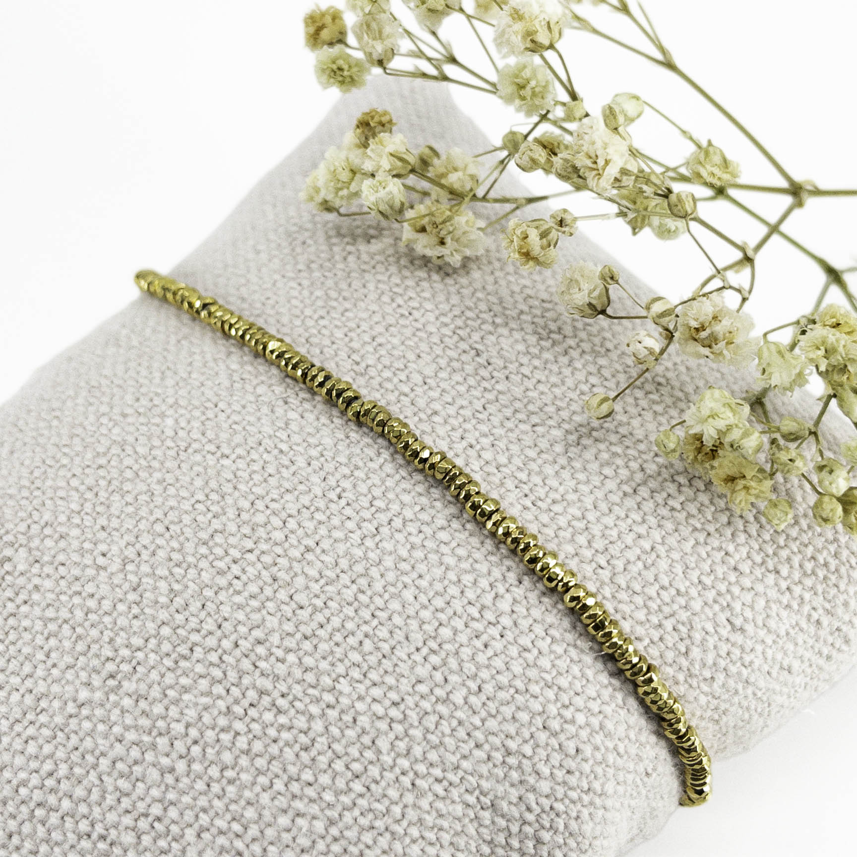 Bracelet en perles de pierre naturelle d'hématite dorée montées sur un cordon ajustable à la taille de votre poignet.