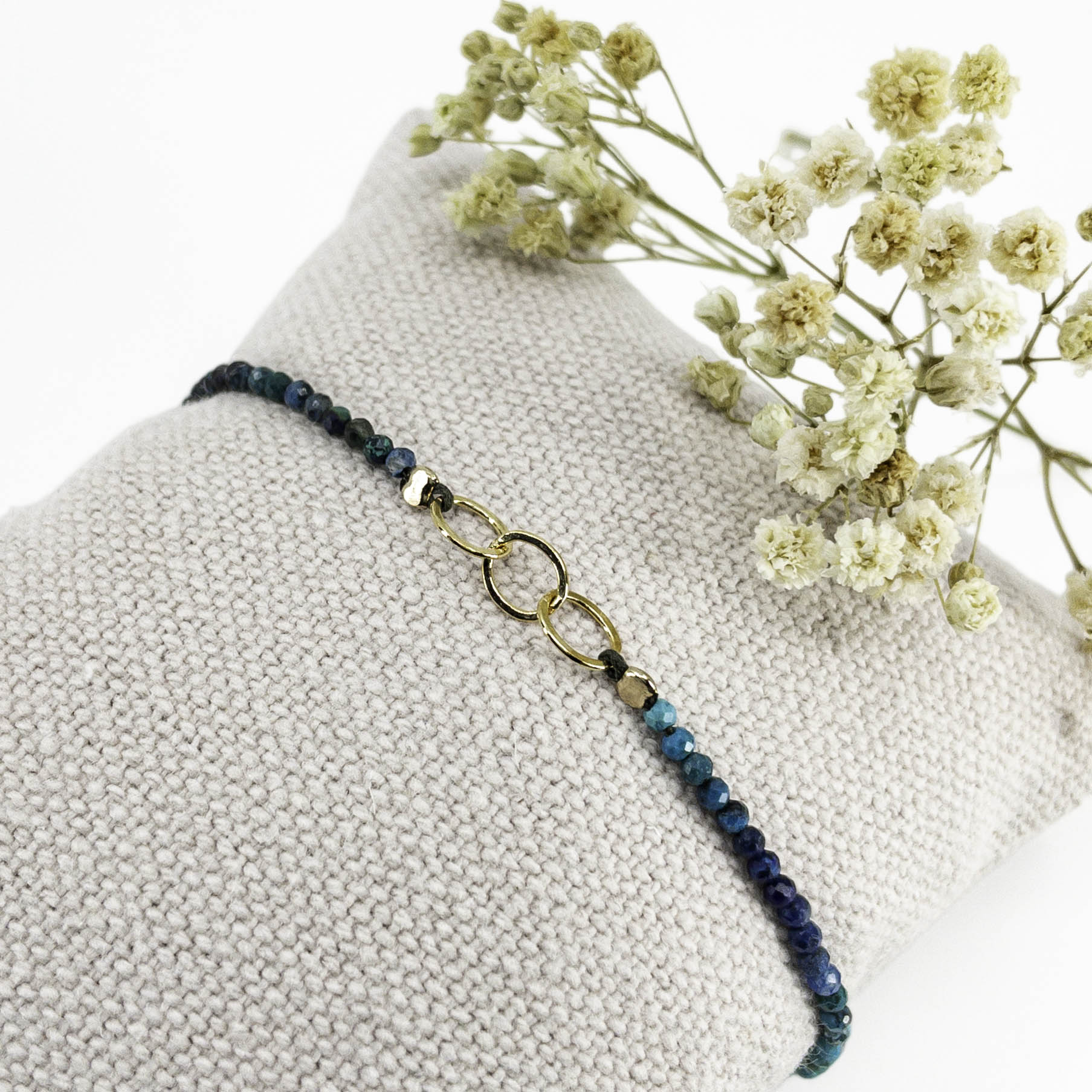 Bracelet réglable en pierres fines naturelles spinelle déclinaison de bleus. Trois anneaux en plaqué or entremêlés