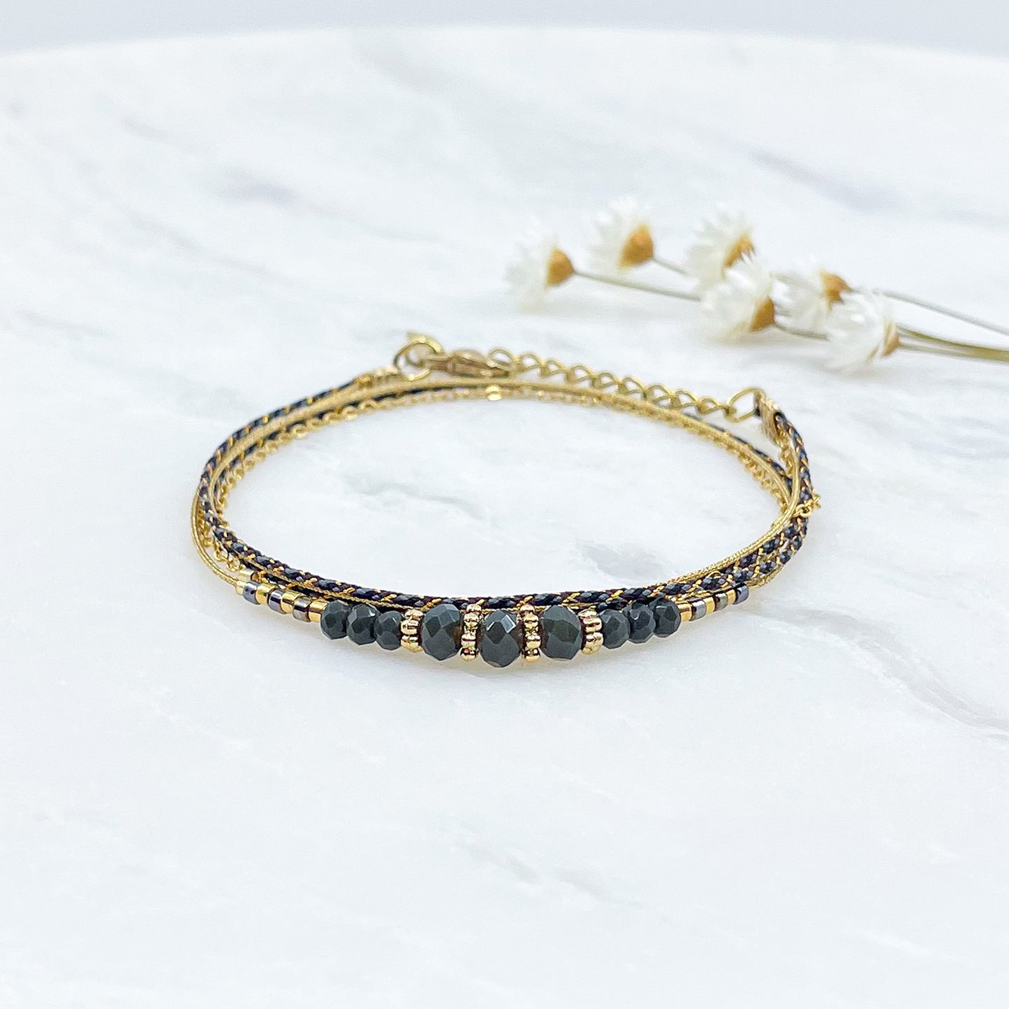 Bracelet en perles de cristal de verre Kaki foncé. Trois liens de cordons et chaîne qui s'enroulent en deux tours sur le poignet.