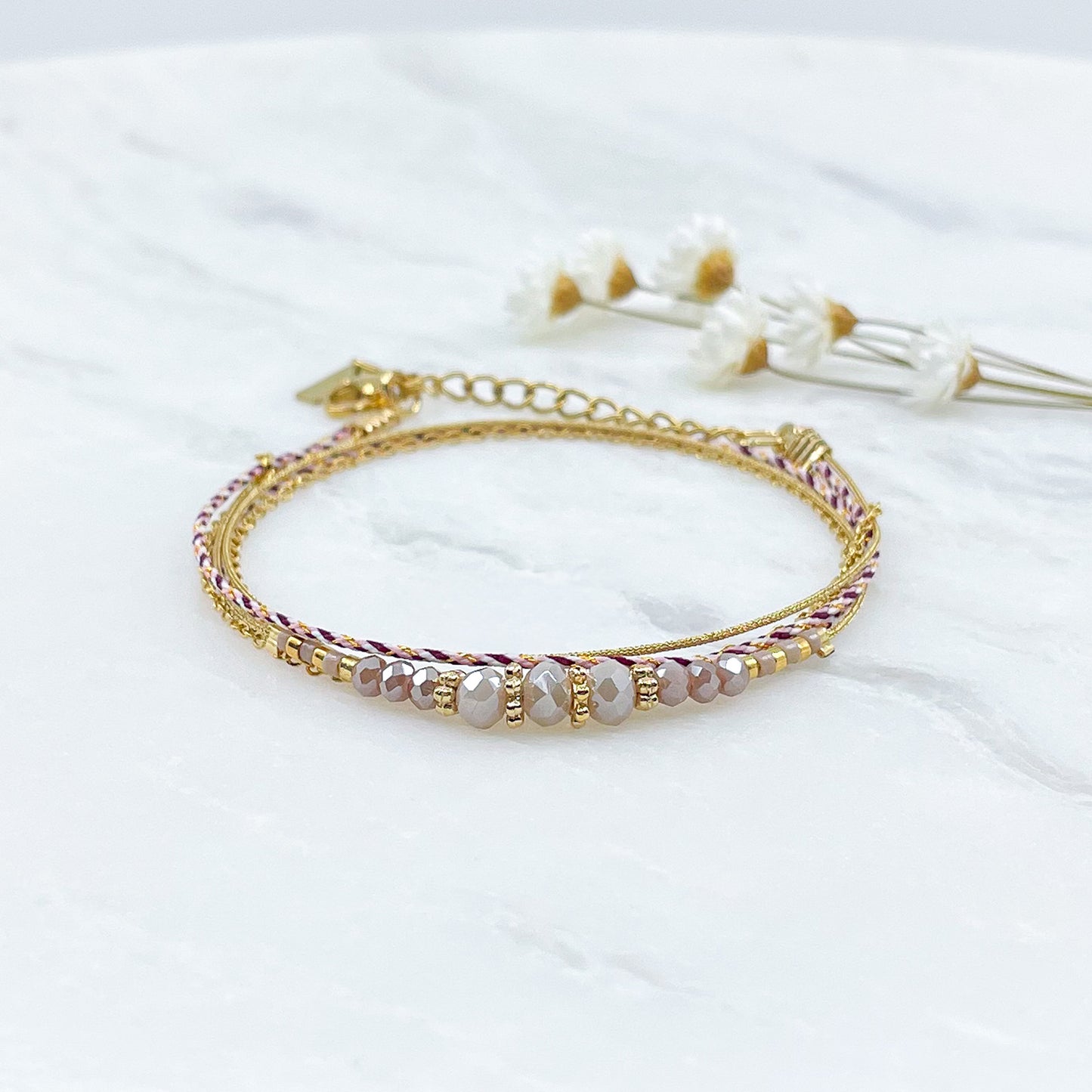 Bracelet composé de 3 liens en cordons colorés et doré et chaîne dorée. Sur l'un d'eux sont montées des perles de verre de Cristal Rose et Rose pâle aux beaux reflets.