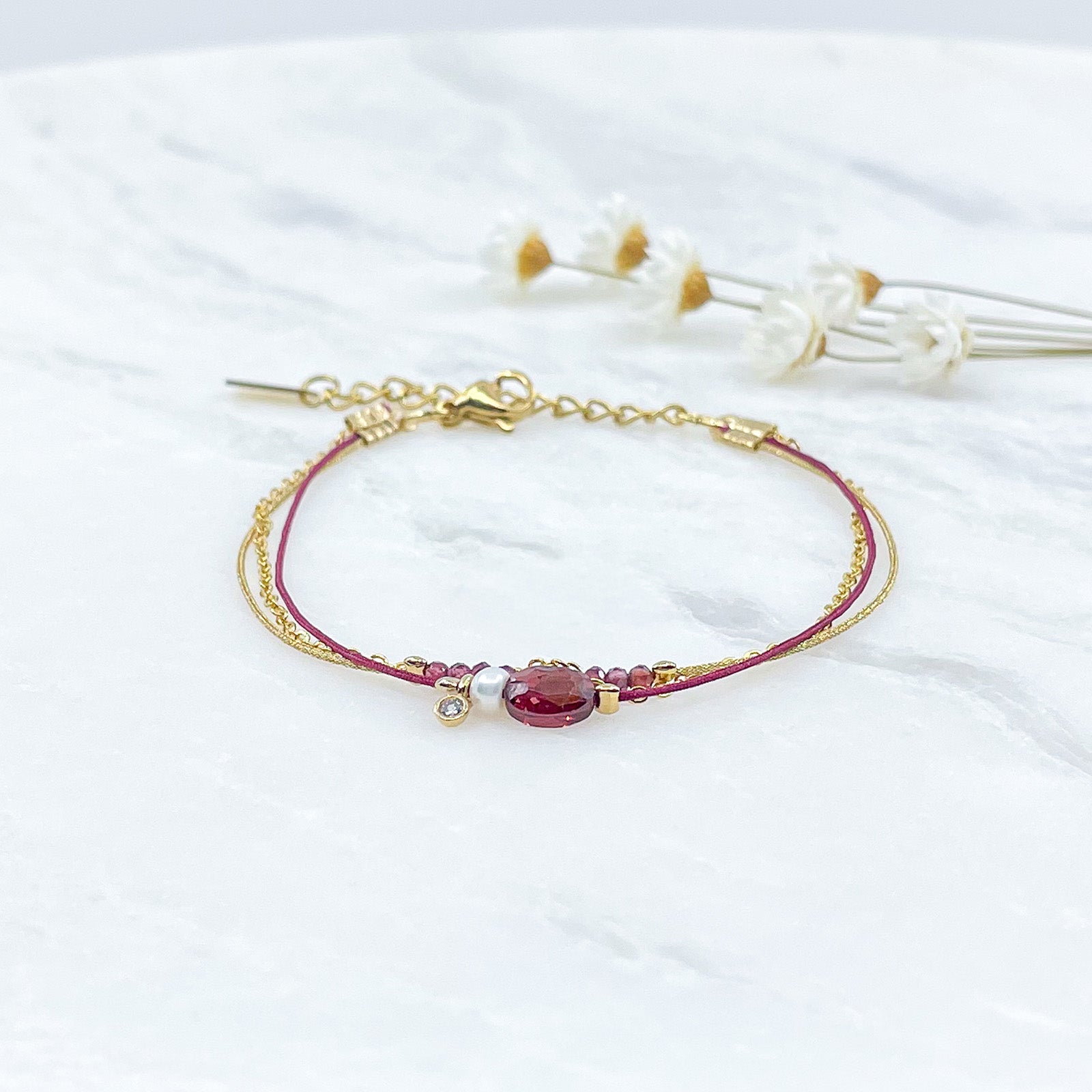 Bracelet Grenat et Perle de Culture montés sur différents liens cordons et chaîne dorée.