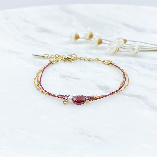 Bracelet Grenat et Perle de Culture montés sur différents liens cordons et chaîne dorée.