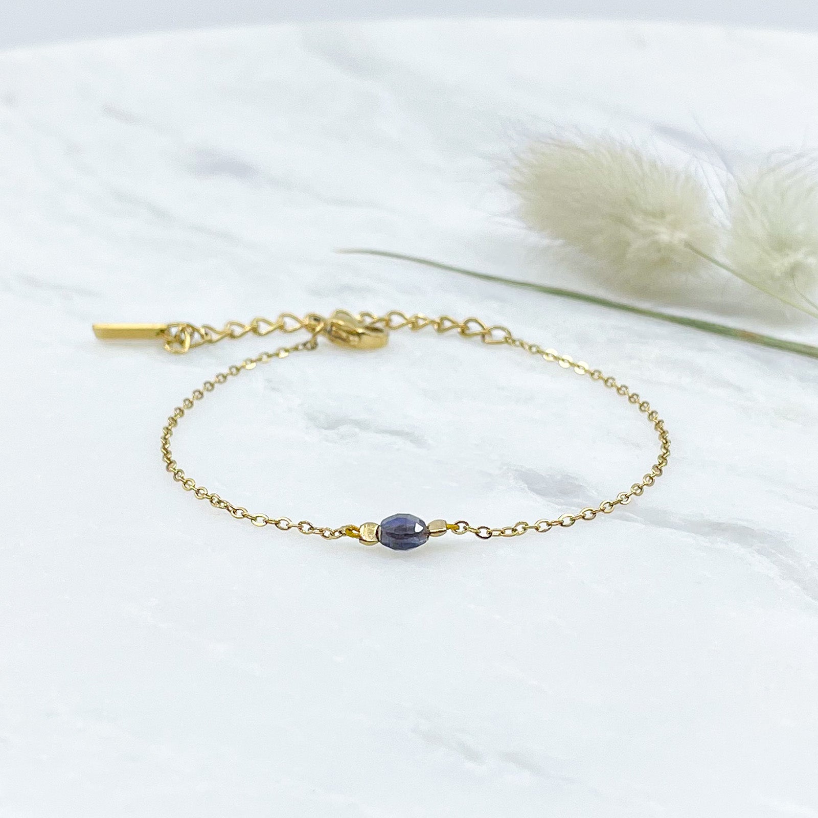 Bracelet perle de iolite bleu comme un solitaire monté sur une chaîne en acier inoxydable doré.