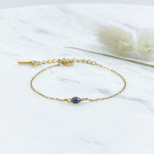 Bracelet perle de iolite bleu comme un solitaire monté sur une chaîne en acier inoxydable doré.