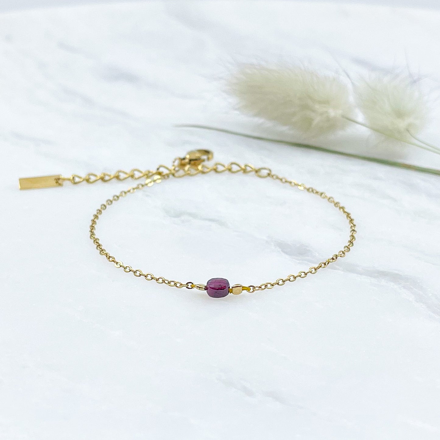 Bracelet perle de pierre naturelle de grenat rouge bordeaux montée sur une chaîne dorée.