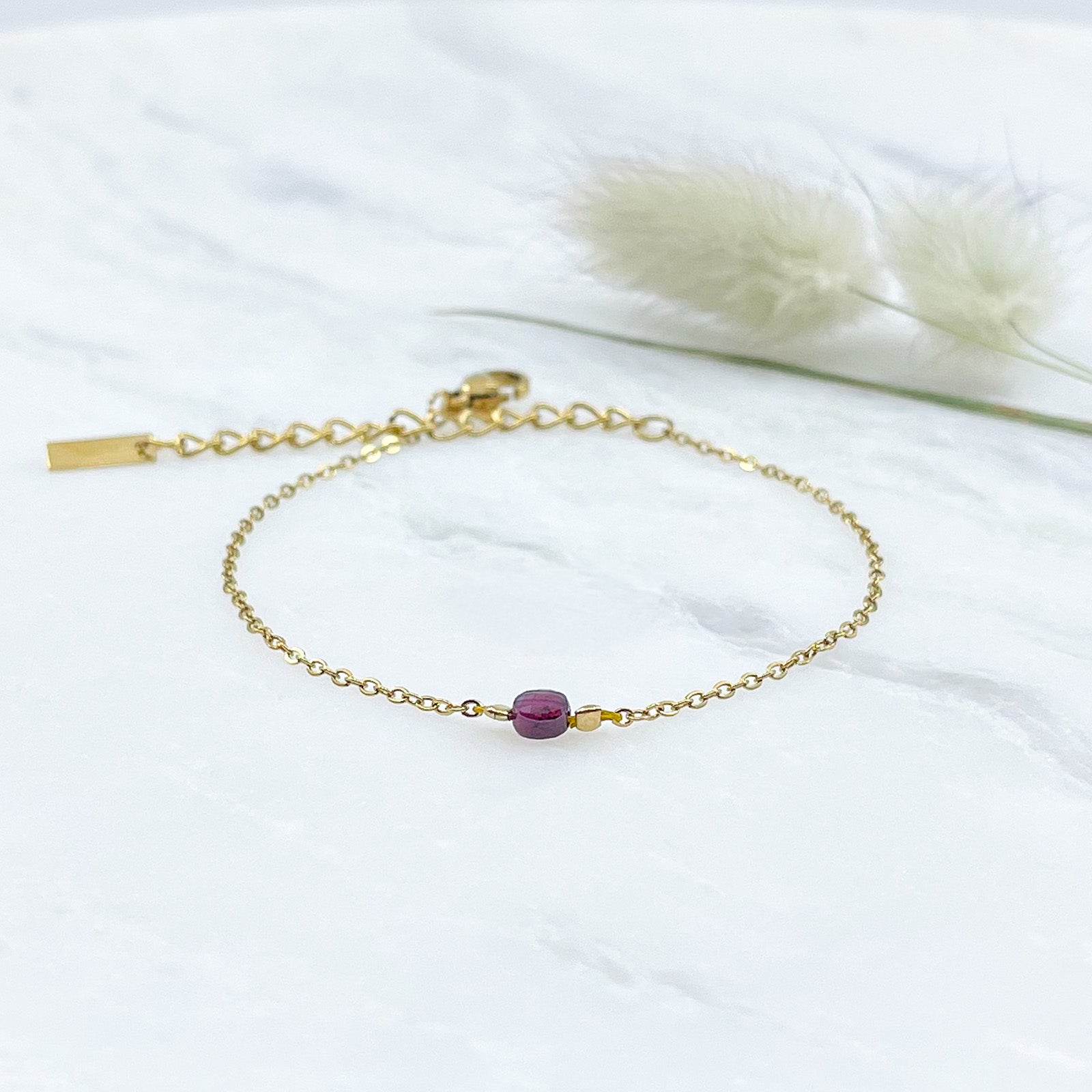 Bracelet perle de pierre naturelle de grenat rouge bordeaux montée sur une chaîne dorée.