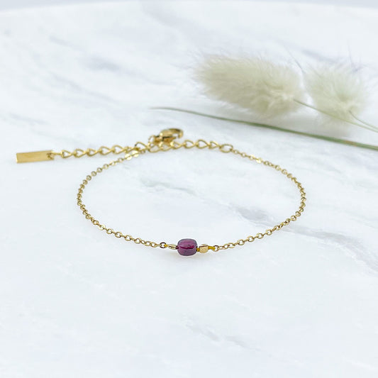 Bracelet perle de pierre naturelle de grenat rouge bordeaux montée sur une chaîne dorée.
