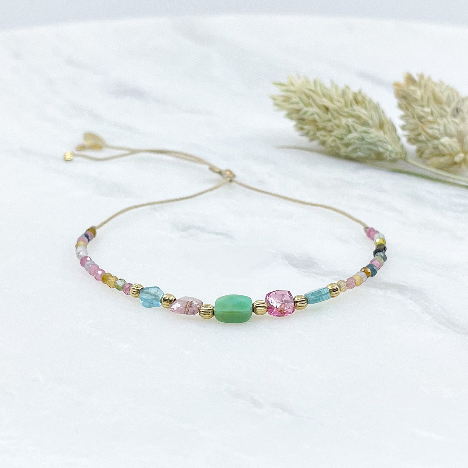 Bracelet ajustable en pierres fines naturelles. Au centre une Agathe d'Herbe carrée verte. Encadrée de deux Tourmalines et deux Aigue-marine.