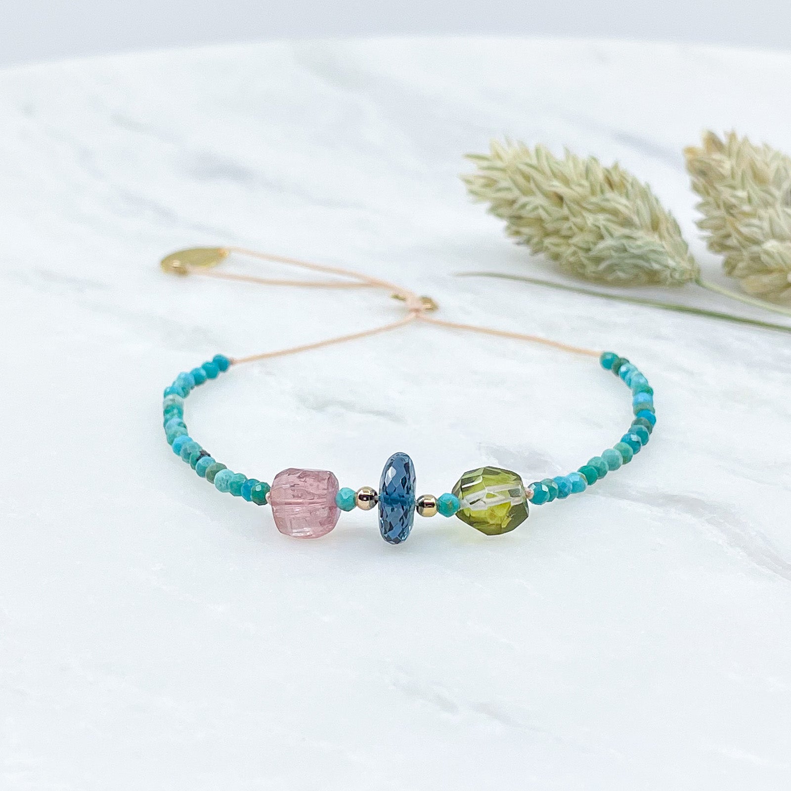 Bracelet aux teintes bleutées ajustable composé de pierres fines naturelles de Turquoise, de deux perles de Tourmaline facettées et d'une très belle perle de Topaze Bleu de Londres facettée