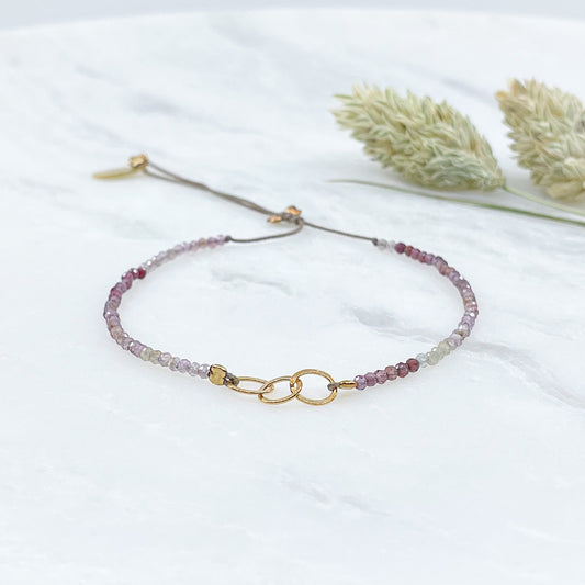 Bracelet réglable en pierres fines naturelles spinelle déclinaison de teinte rose et brune. Trois anneaux en plaqué or entremêlés