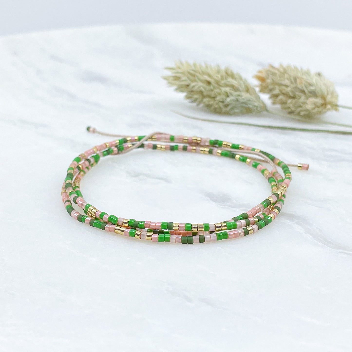 Bracelet ajustable en perles de rocaille vert, rose et or. Trois tours de poignet