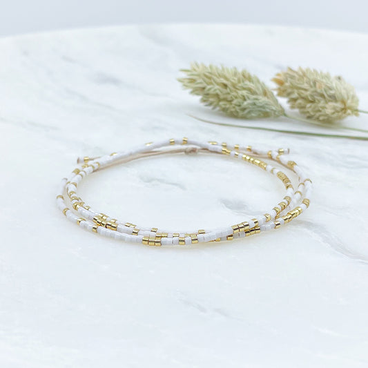 Bracelet ajustable en pierre de rocaille blanc et or. Trois tours de poignet