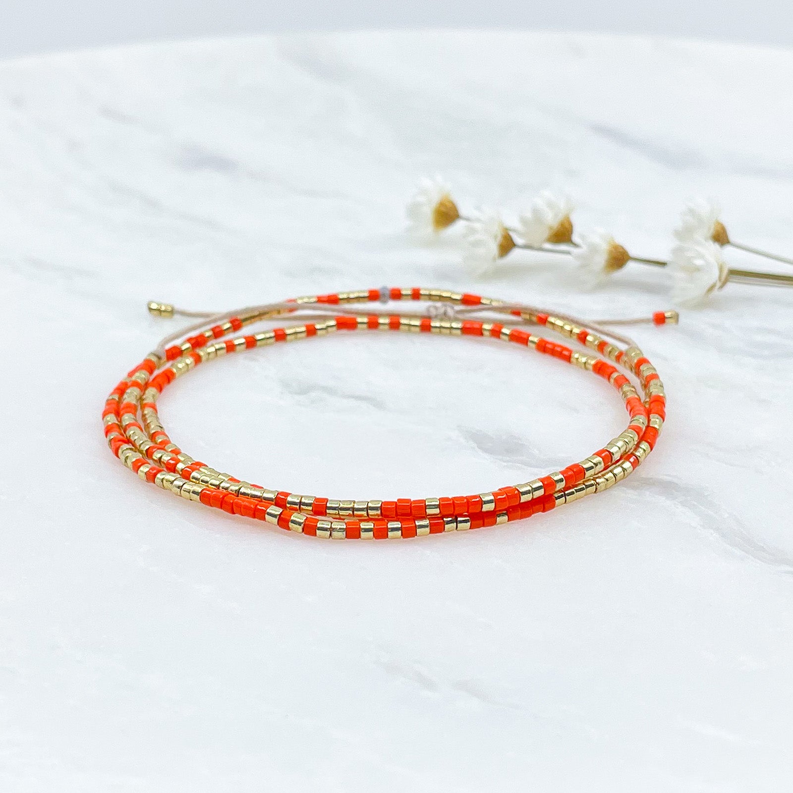 Bracelet ajustable en pierre de rocaille orange pétillant et or. Trois tours de poignet
